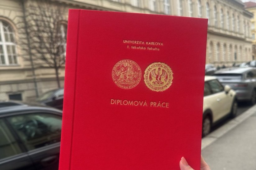 Červená diplomka s logy univerzity a fakulty